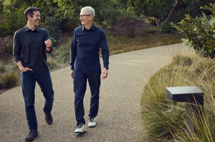 John Ternus and Tim Cook walking together at Apple Park